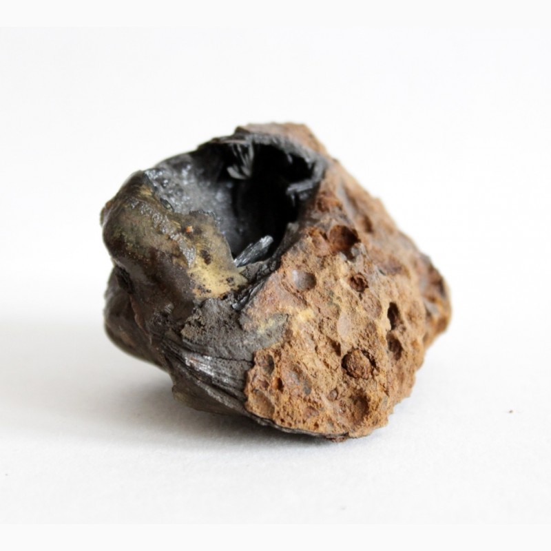 Фото 7. Кристаллы вивианита, псиломелан в полости ископаемой раковины в железной руде